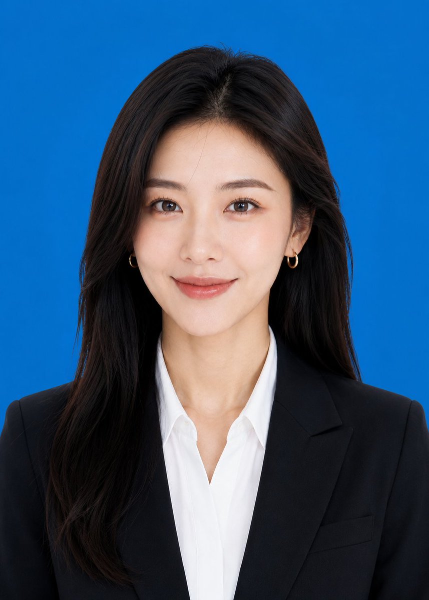 A tidy, passport-style headshot cut from your own portrait, with a plain blue backdrop, formal clothing, a straight-on face and a light smile. It reads as a…